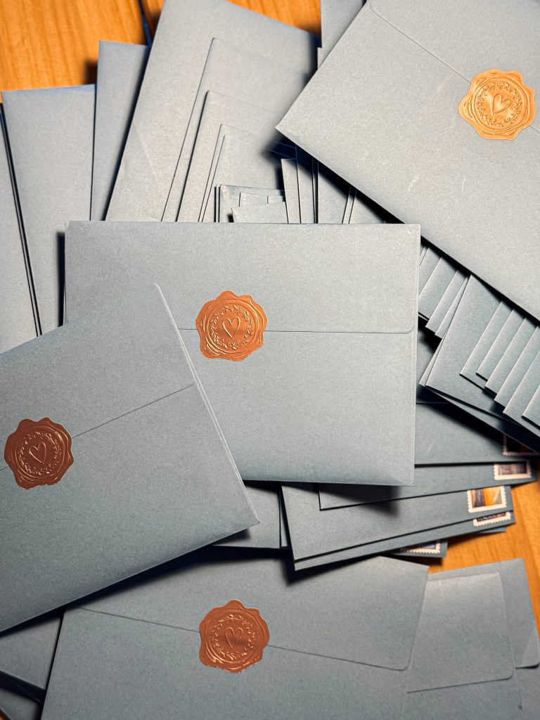 Pile of blue envelopes with gold sticker