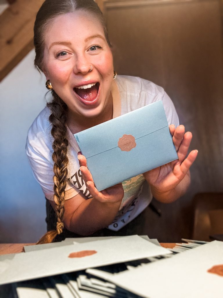 Kayla Cornish holding up a Slow & Savor envelope