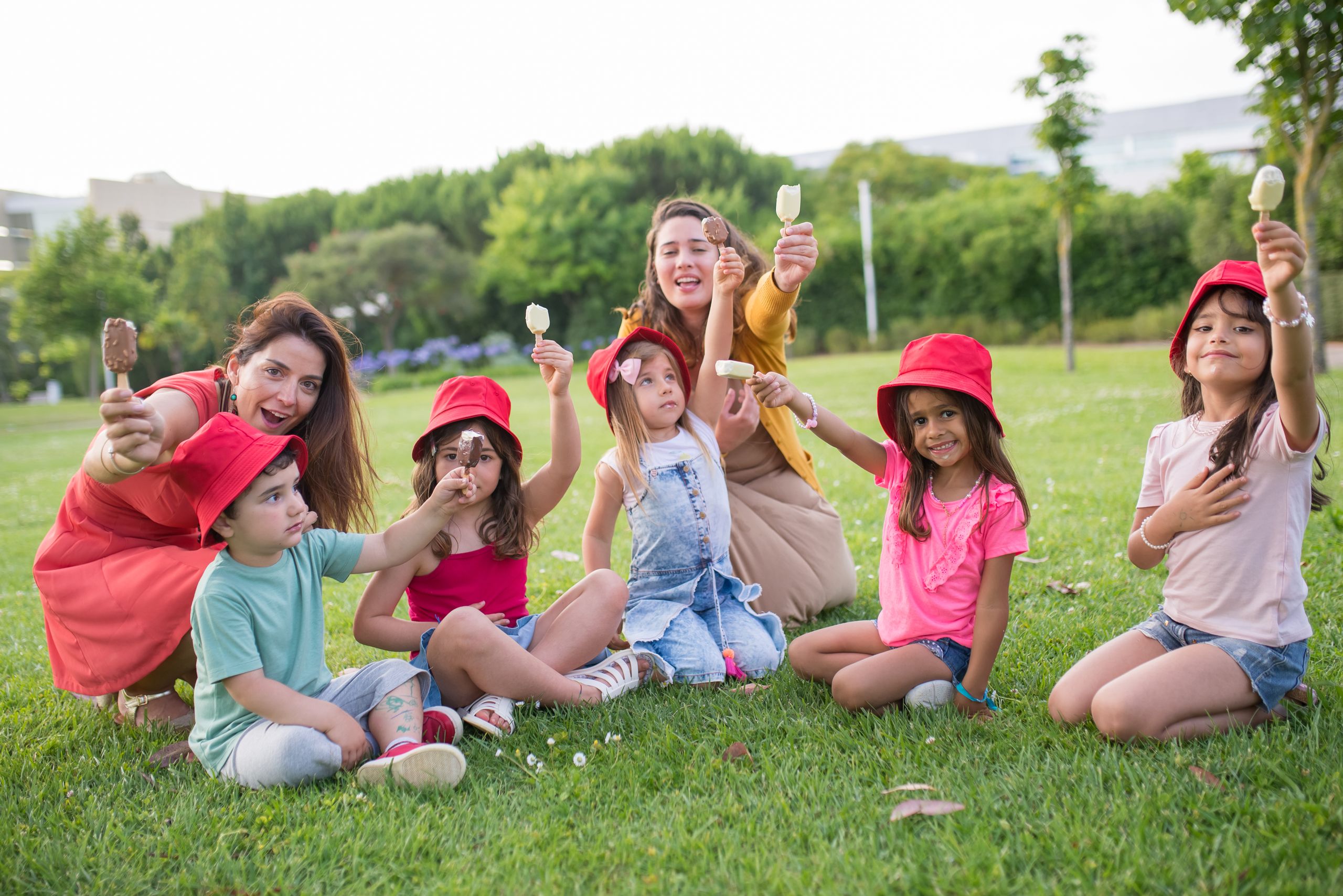 A joyful family enjoying ice cream on a sunny day in a Portuguese park.