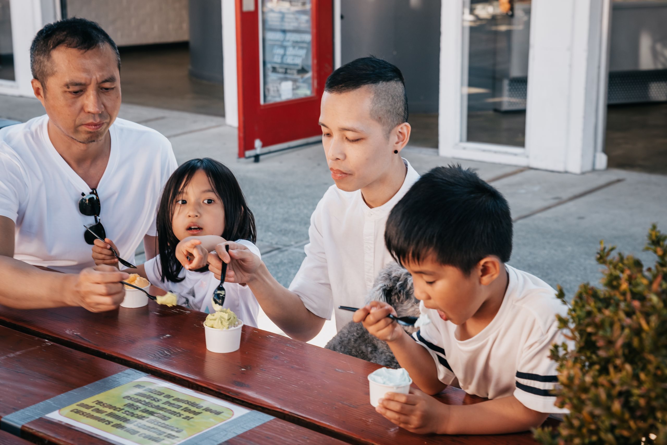 A family savoring ice cream outdoors, capturing a moment of togetherness and joy.