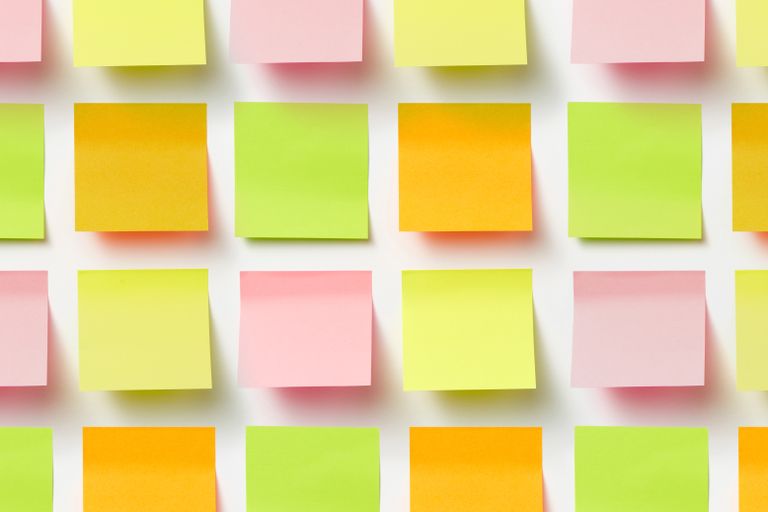 Grid of colorful sticky notes creating a vibrant pattern on a white surface.